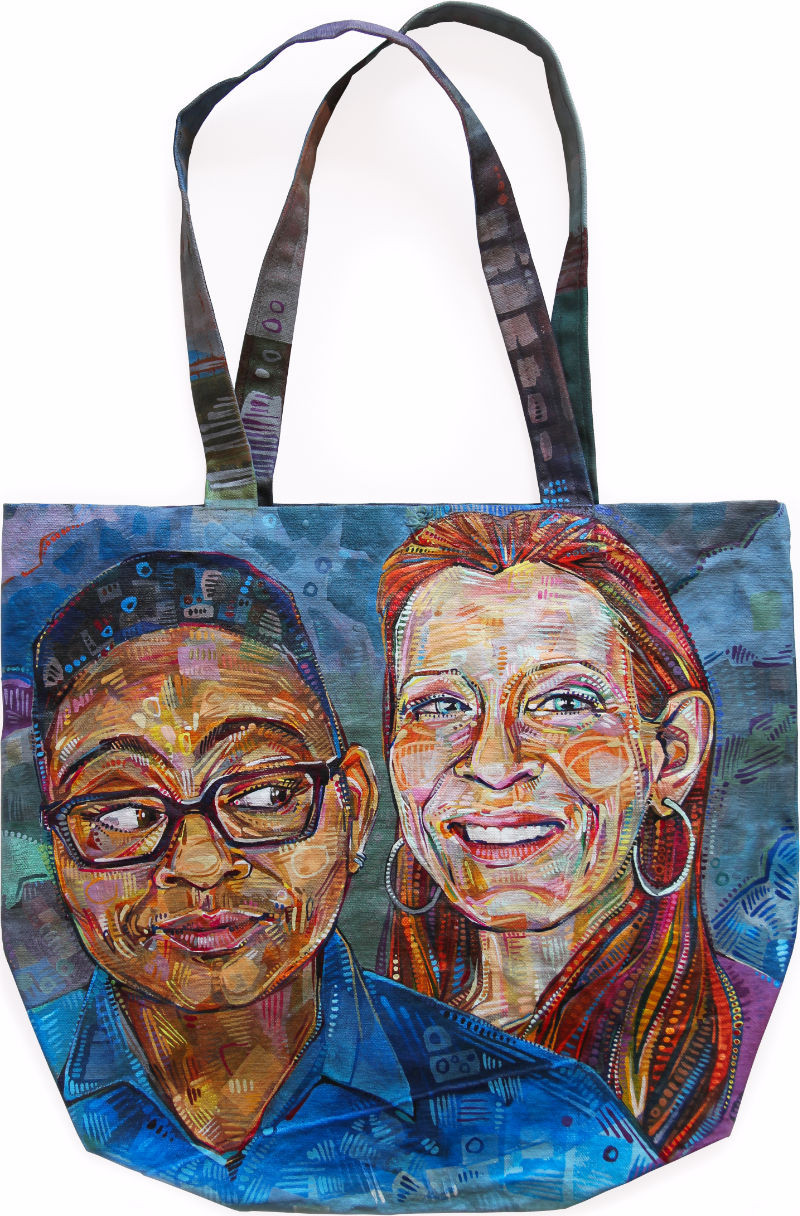 portrait d’une femme noire et une femme blanche peint sur un sac à main en toile