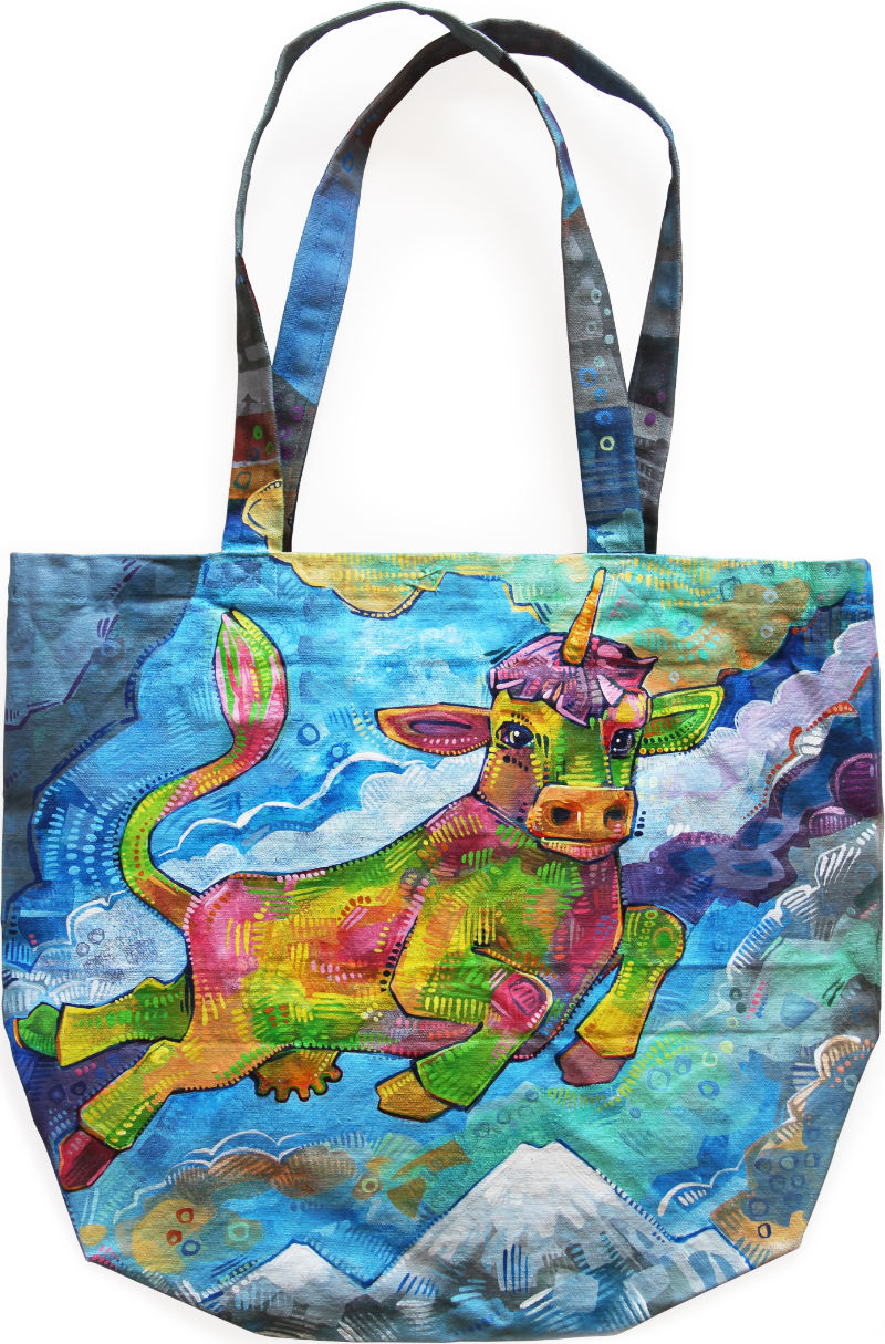 a canvas tote bag with a cow unicorn painted on it