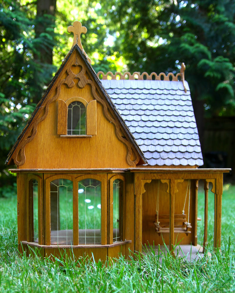 dollhouse in a wooded back yard