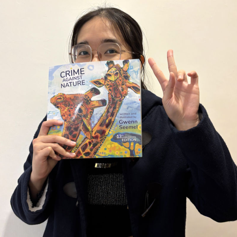 Vivian holding Crime Against Nature 13th Anniversary Edition