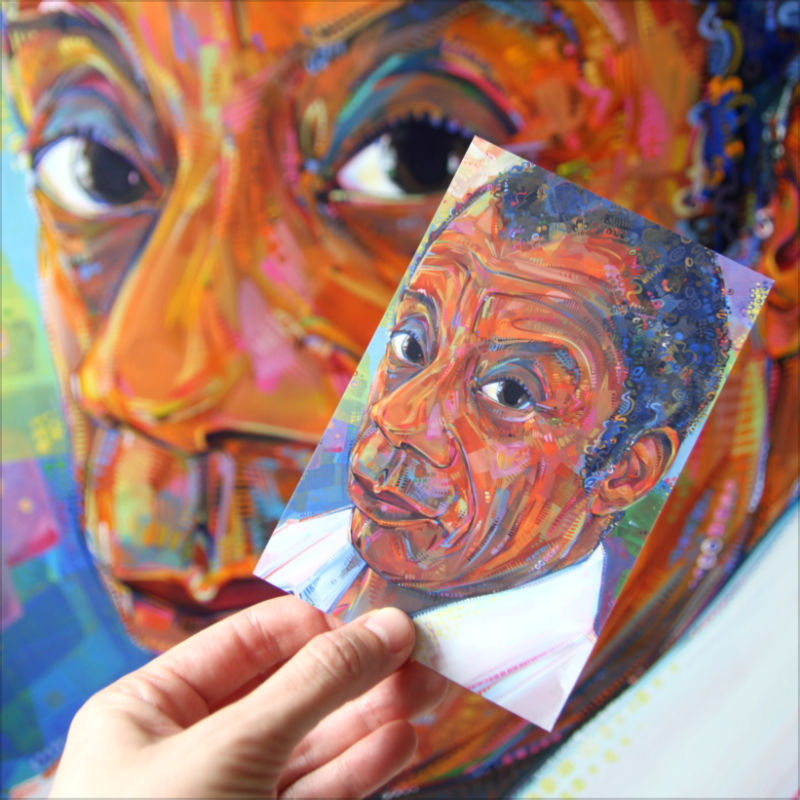 Gwenn Seemel tenant une carte postale de son art